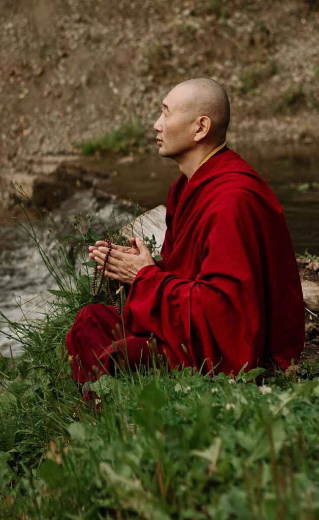 Monje budista utilizando un japa mala para meditar.